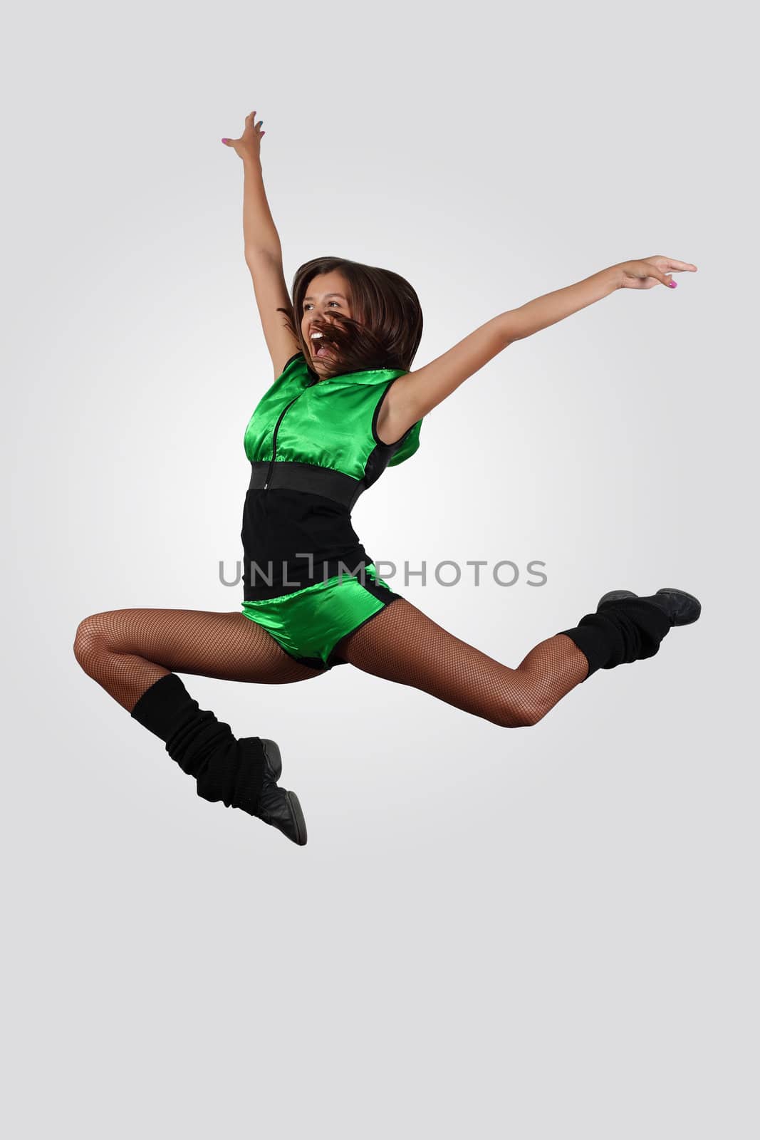 Young female dancer jumping against white background