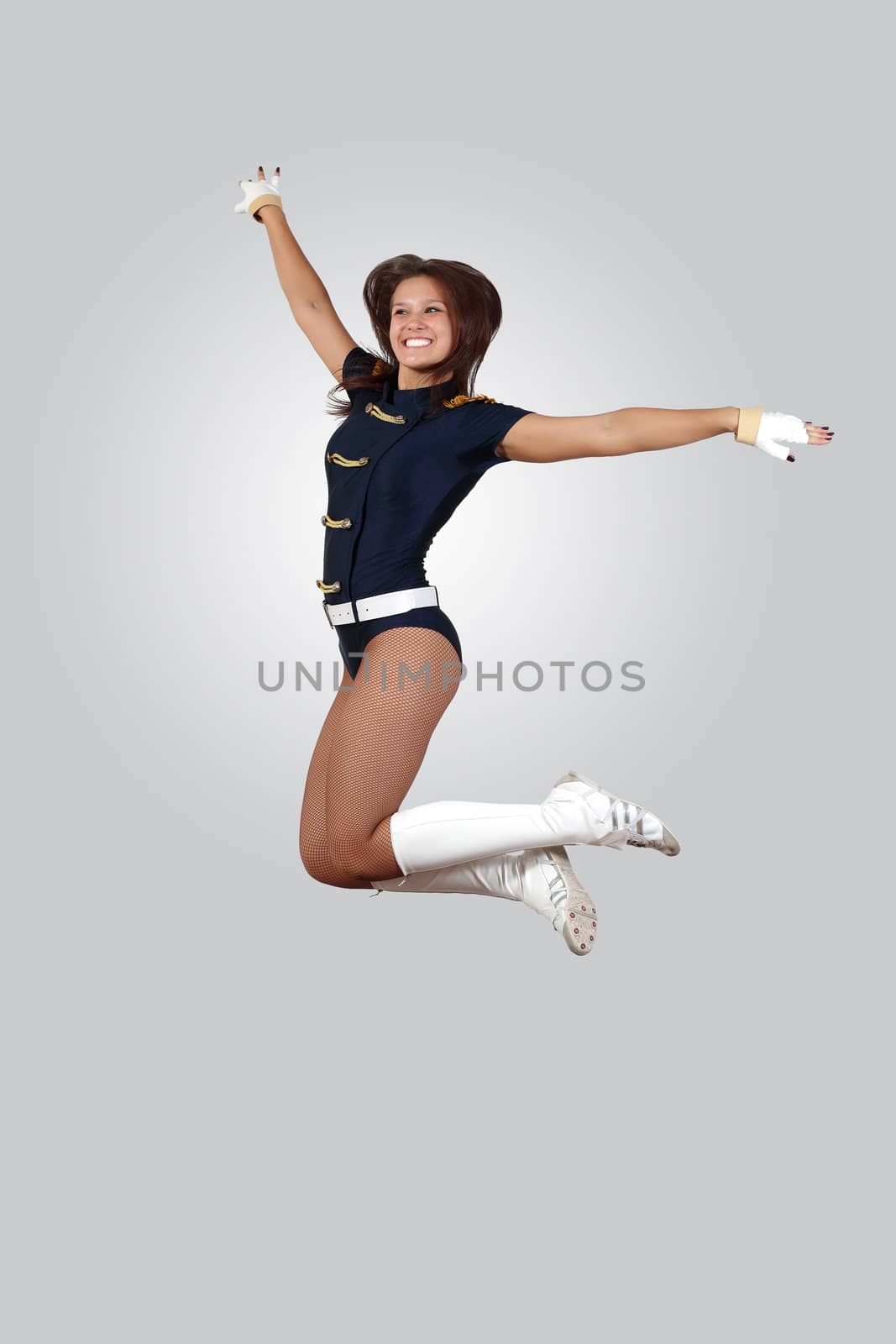 Young female dancer jumping against white background