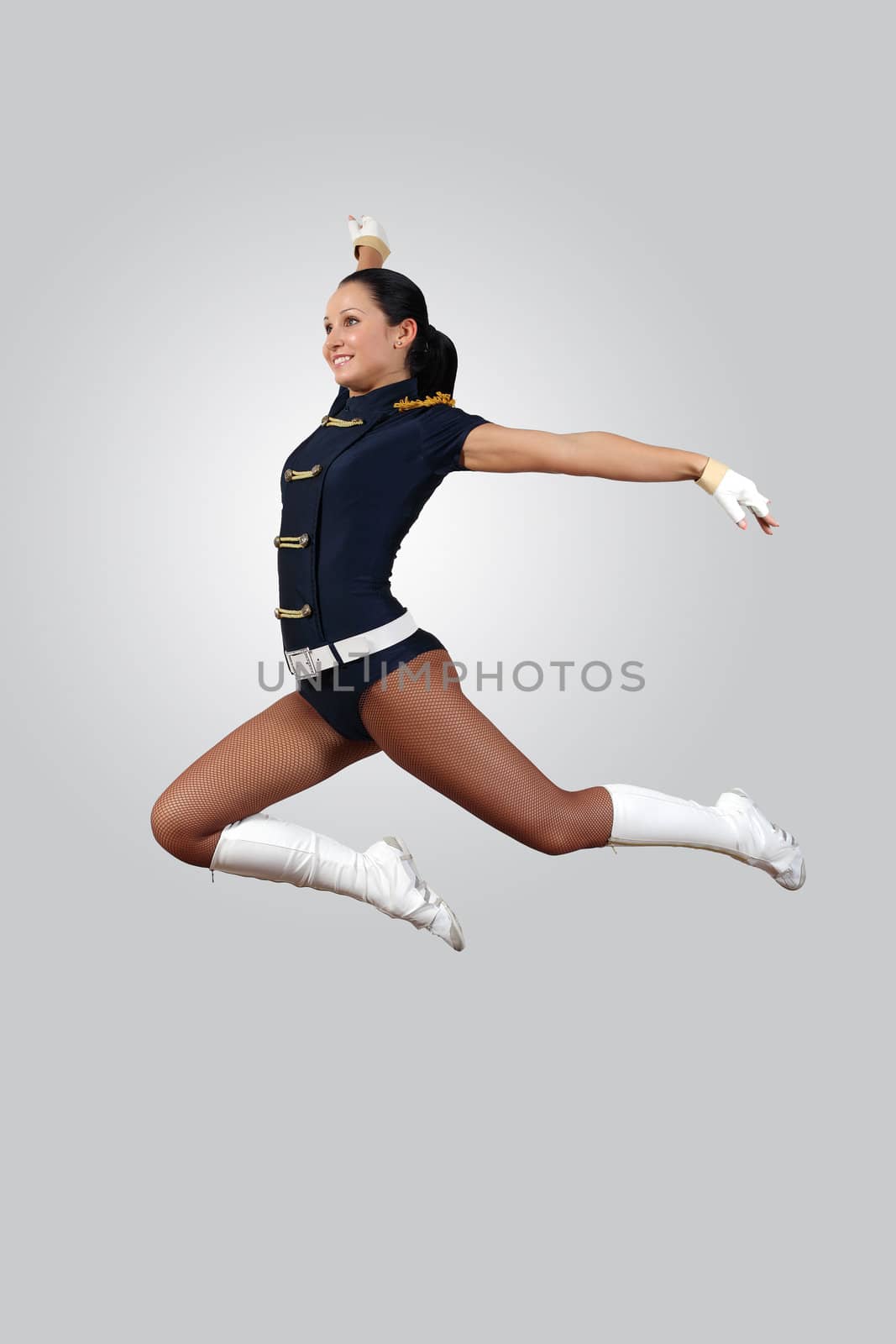 Young female dancer jumping against white background