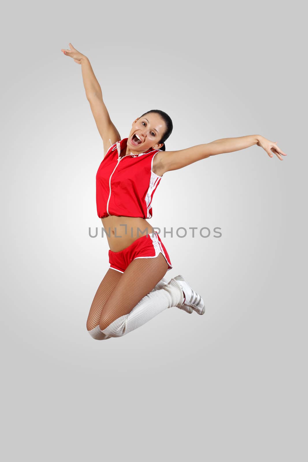 Young female dancer jumping against white background