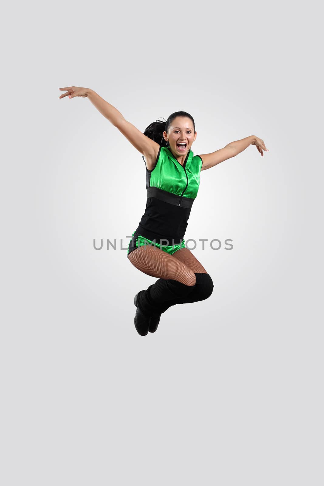 Young female dancer jumping against white background