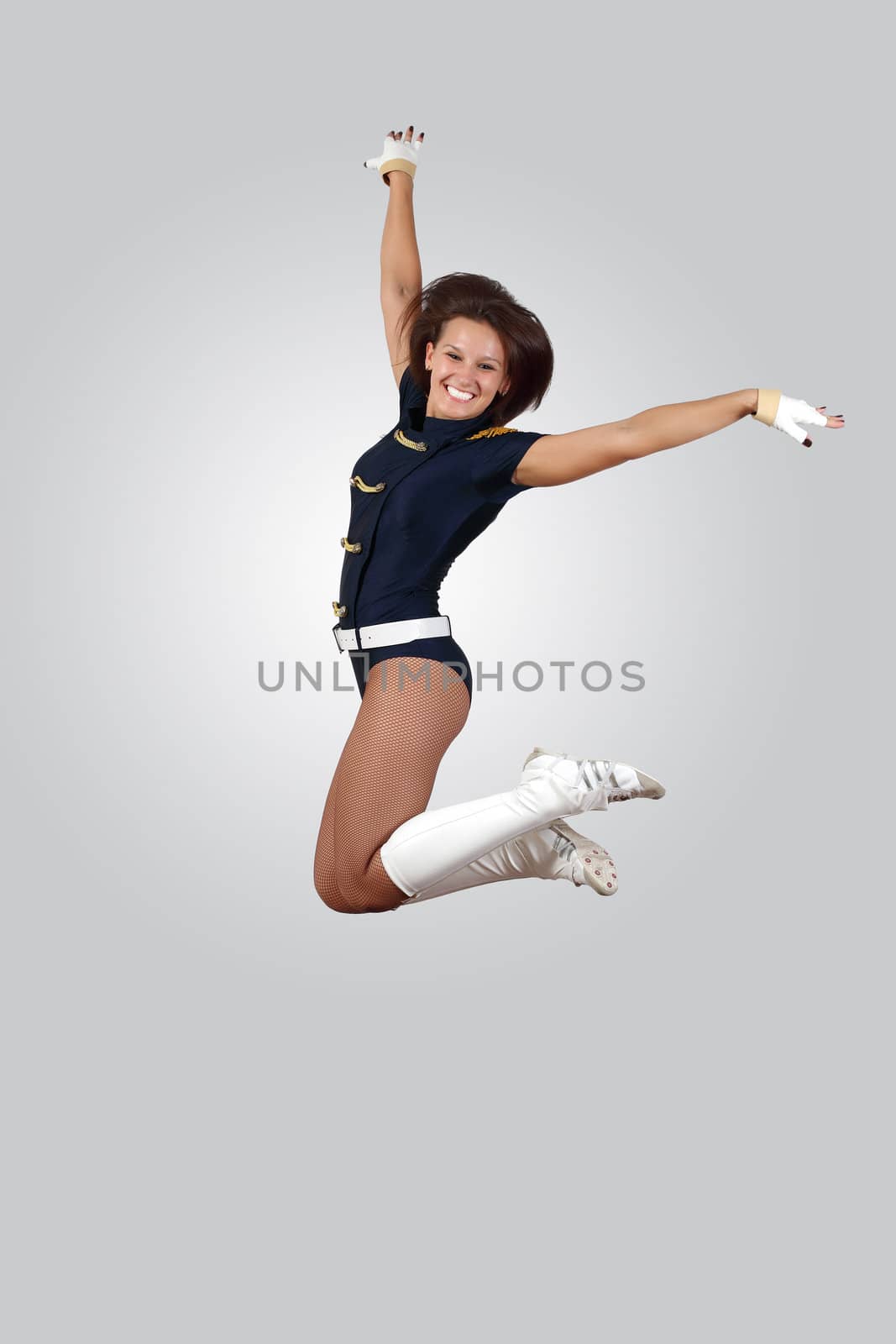 Young female dancer jumping against white background