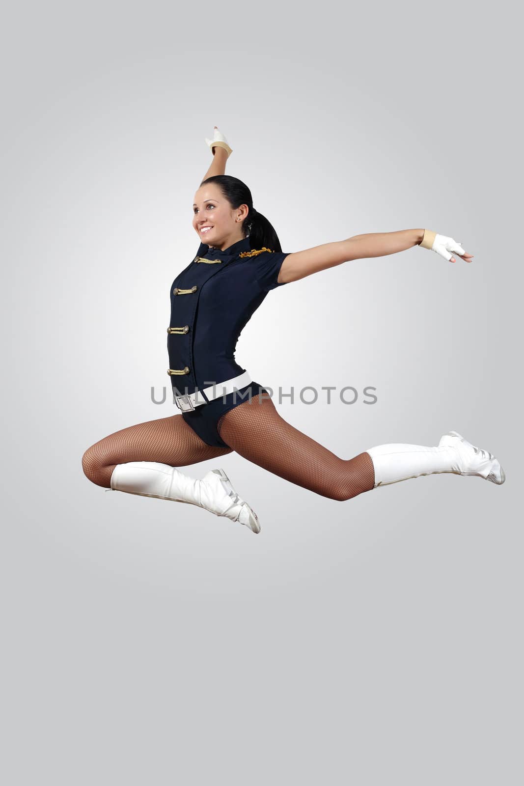 Young female dancer jumping against white background