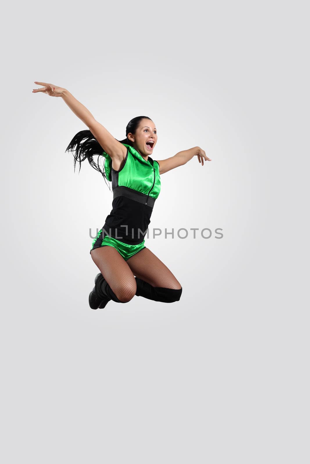 Young female dancer jumping against white background