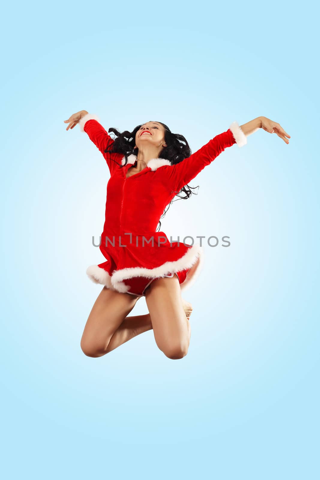 Happy smiling woman in red xmas costume jumping high