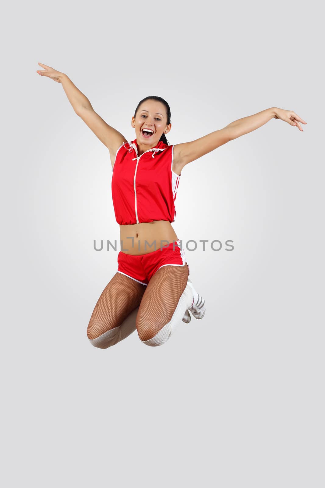 Young female dancer jumping against white background