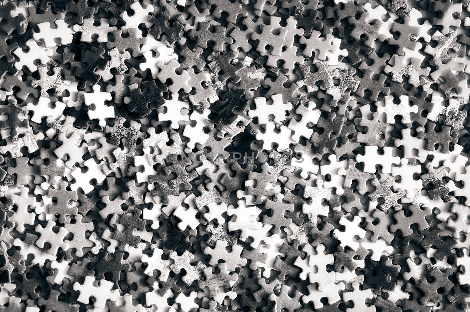 Unfinished monochrome puzzle pieces close up detail