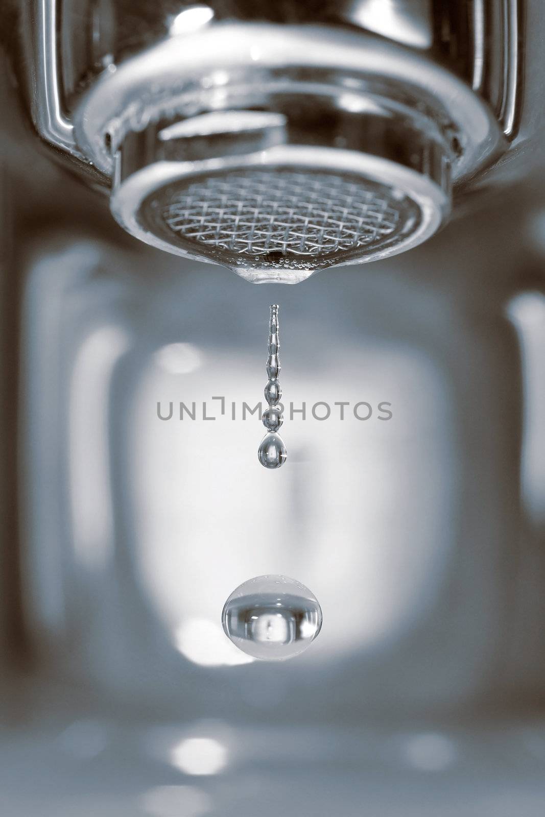 Water drop falling form a faucet in a bathroom, low depth of field