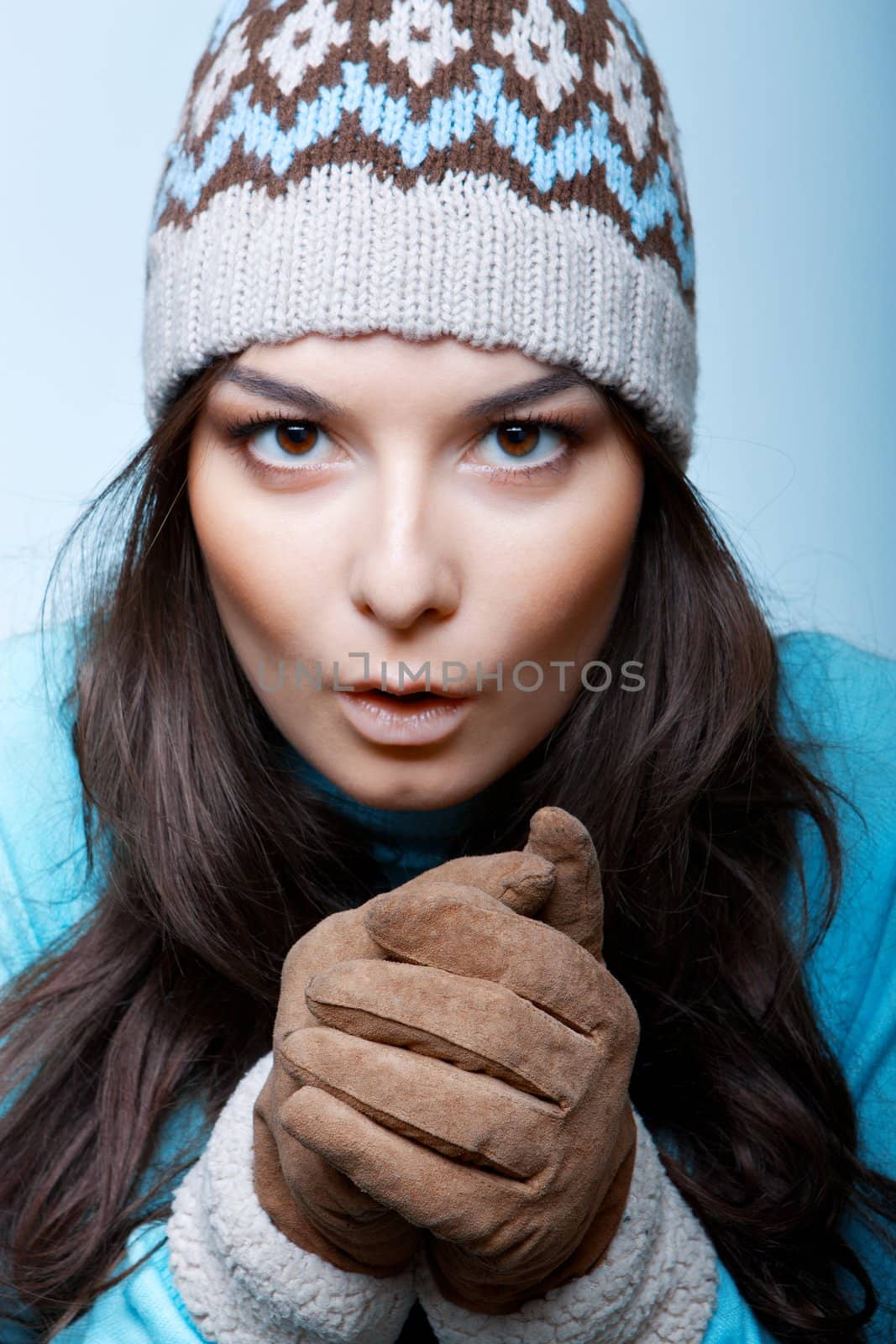 woman warm hands in gloves on blue background