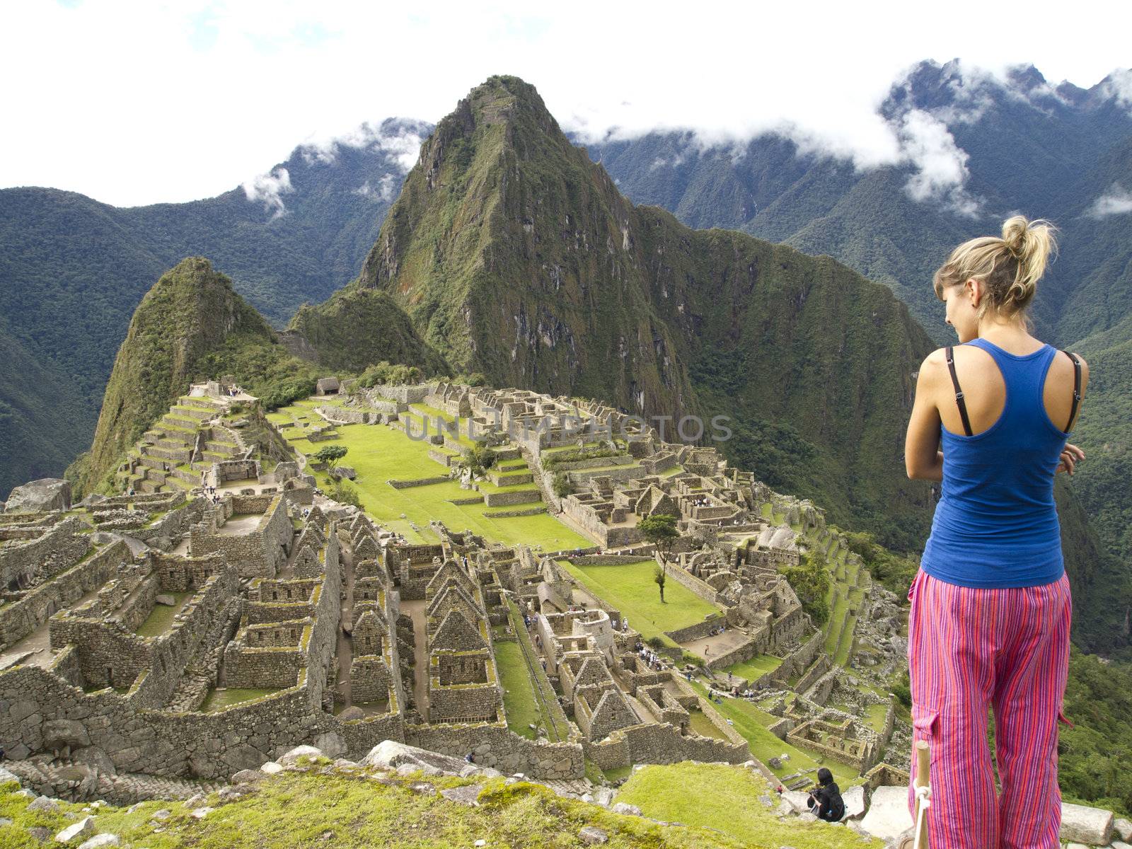 Unidentified tourist looking at the lost city of Machu Picchu in Peru