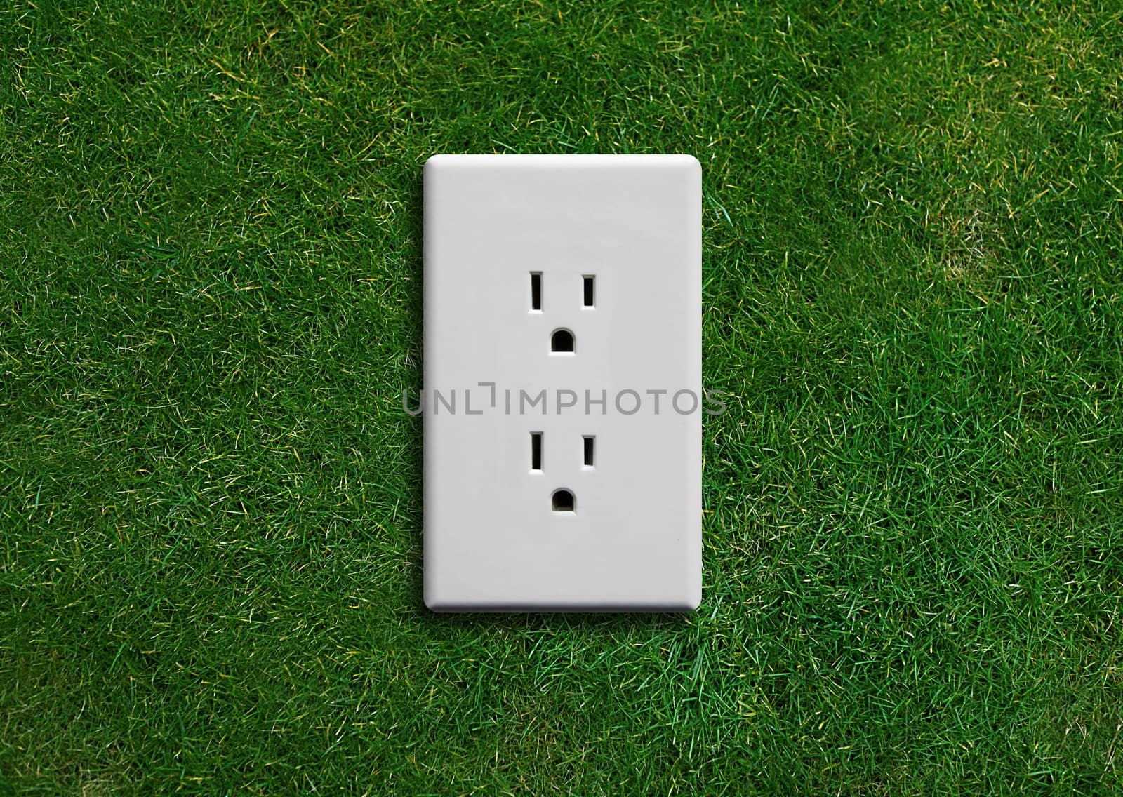 electricity adapter on a green grassland, Green energy concept, Green power.