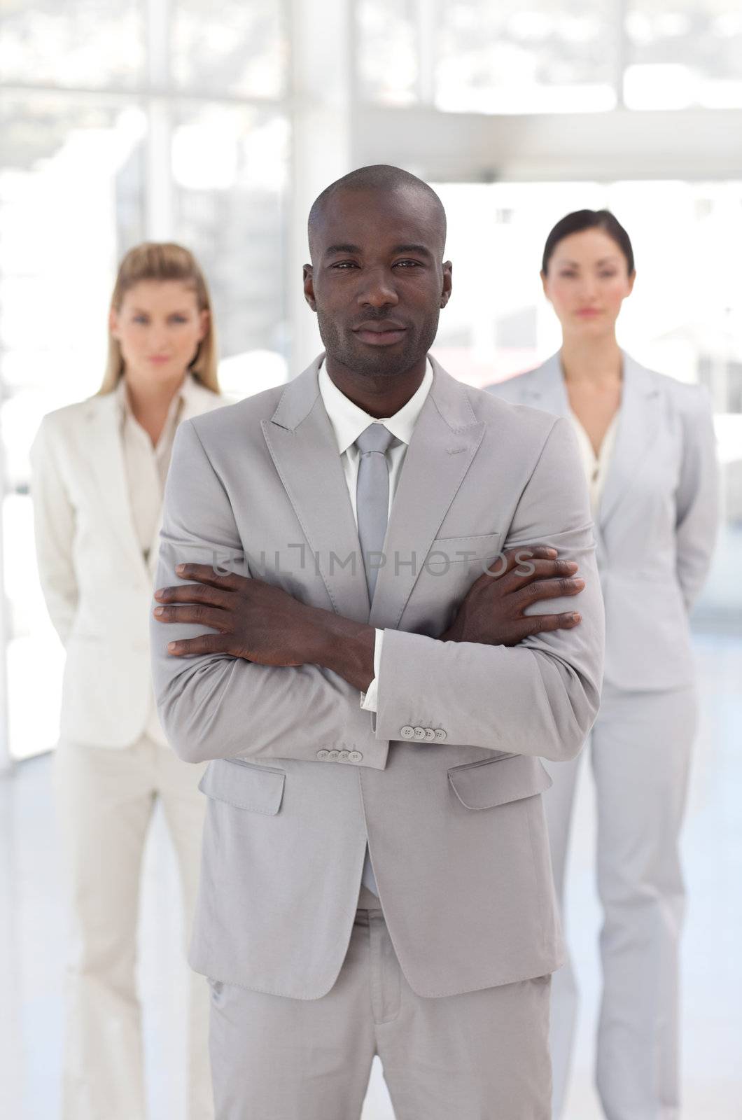 Serious afro-american manager with his team  by Wavebreakmedia