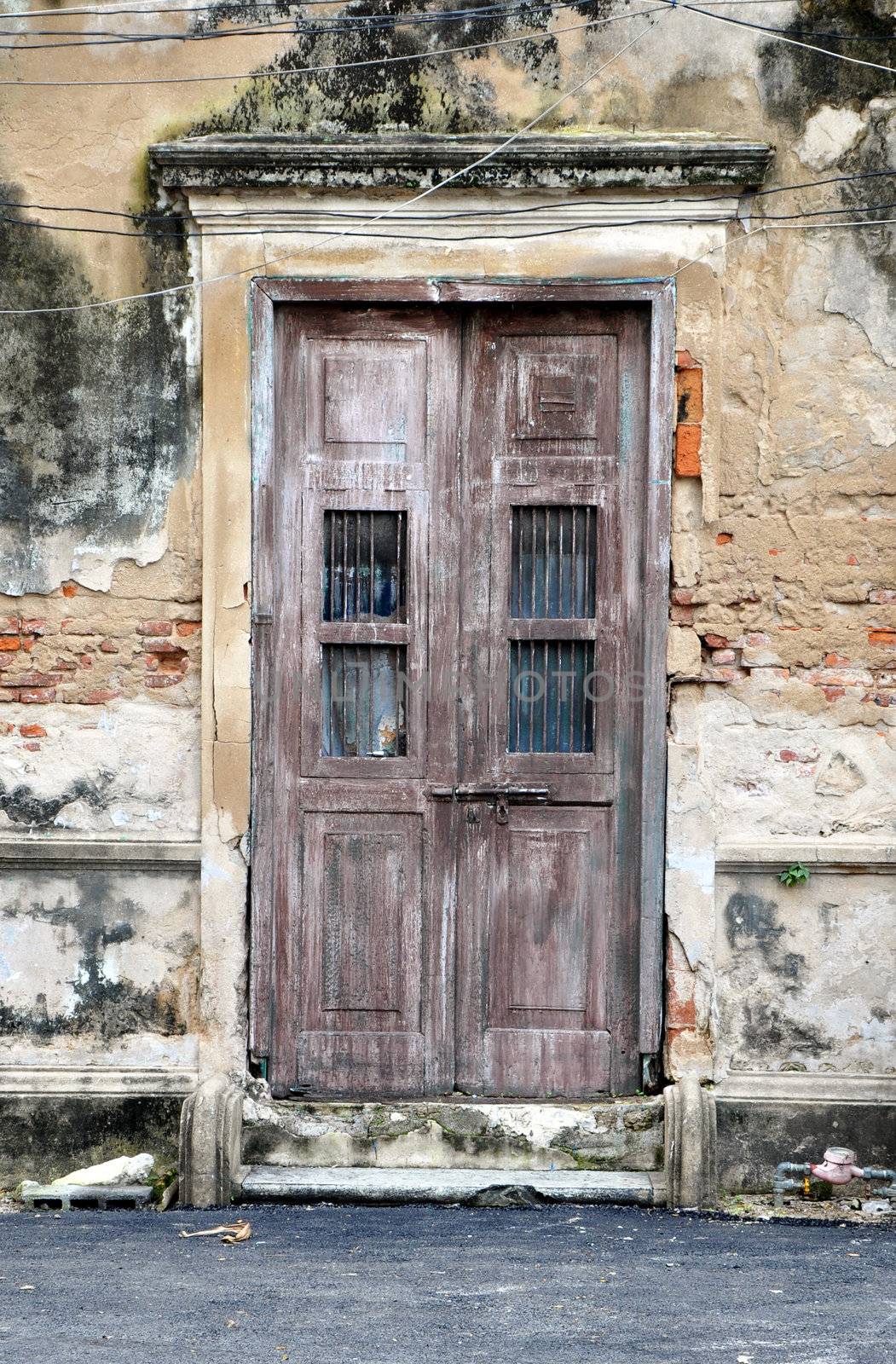 old door of brick building  by siraanamwong