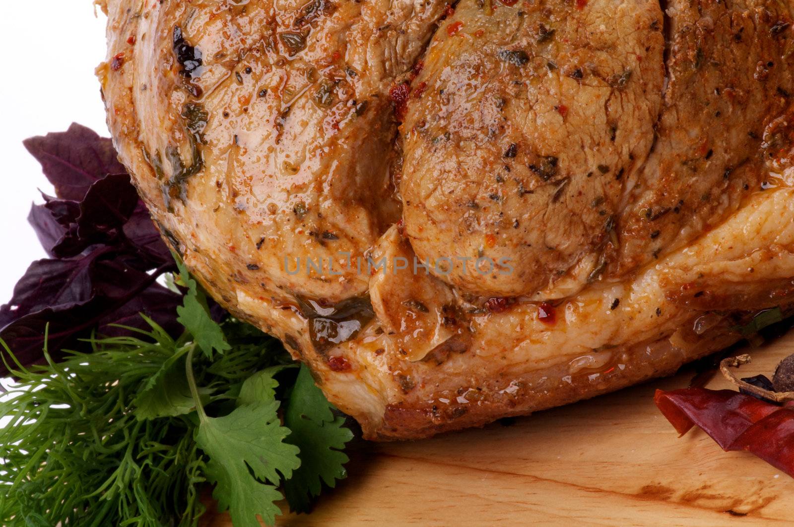 Glazed Spicy Roasted Pork with Herbs, Greens and Chili closeup on Cutting Board