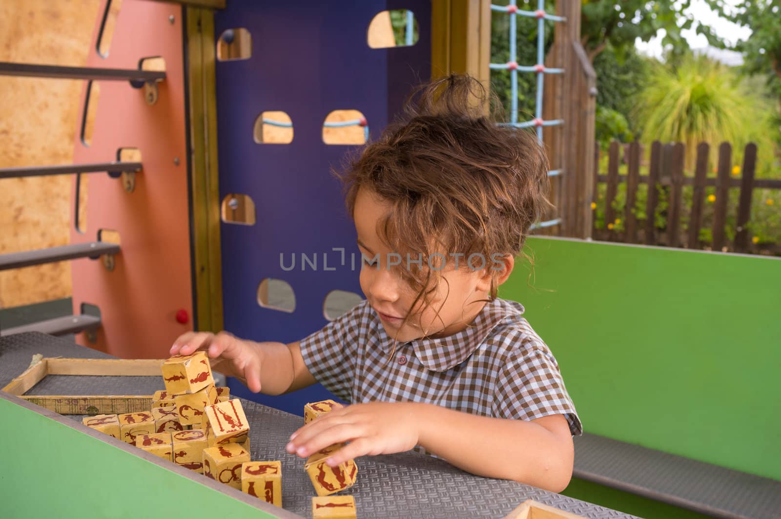 A small girl having fun with a vintage alphabet puzzle game