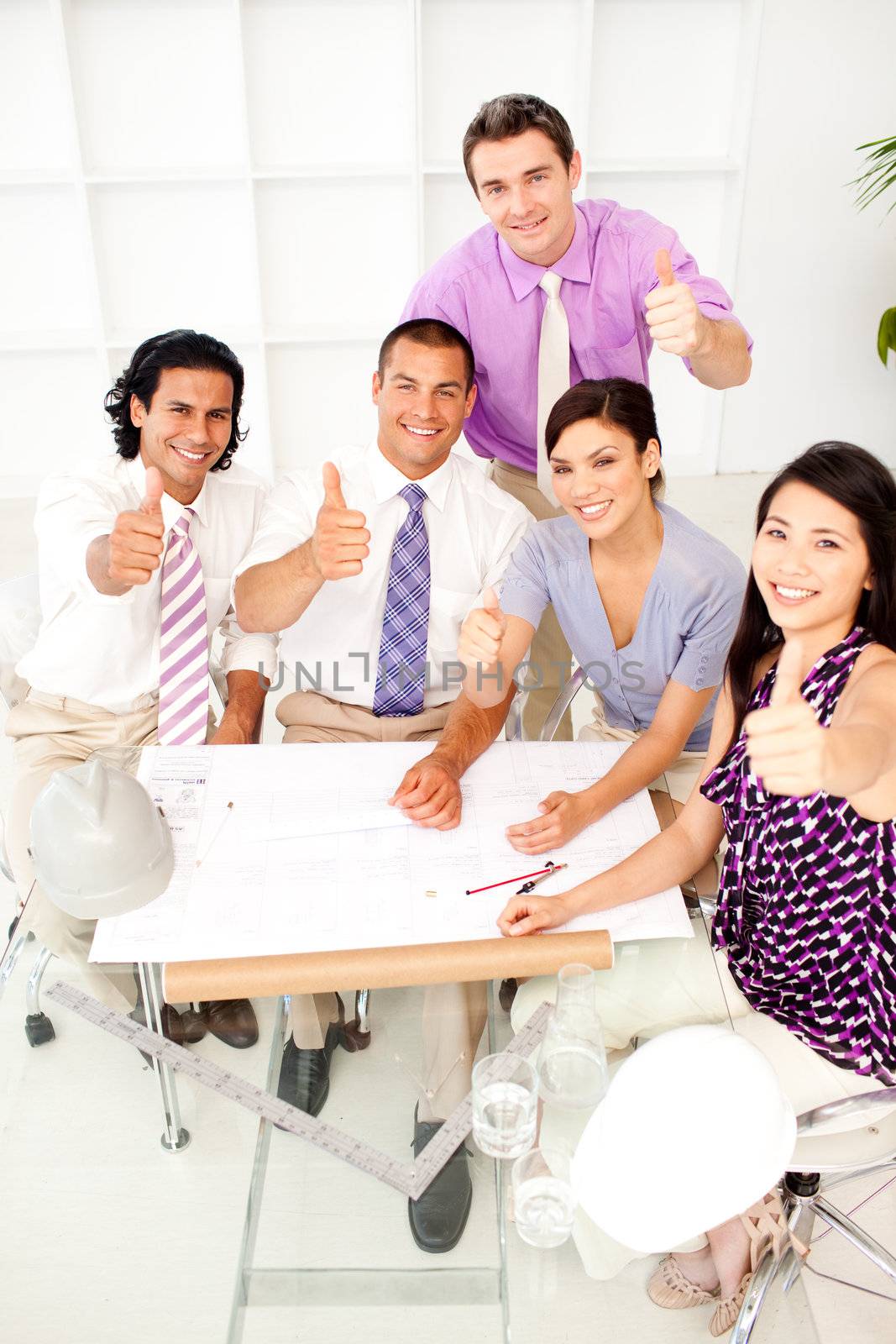 A group of architects with thumbs up in a meeting by Wavebreakmedia