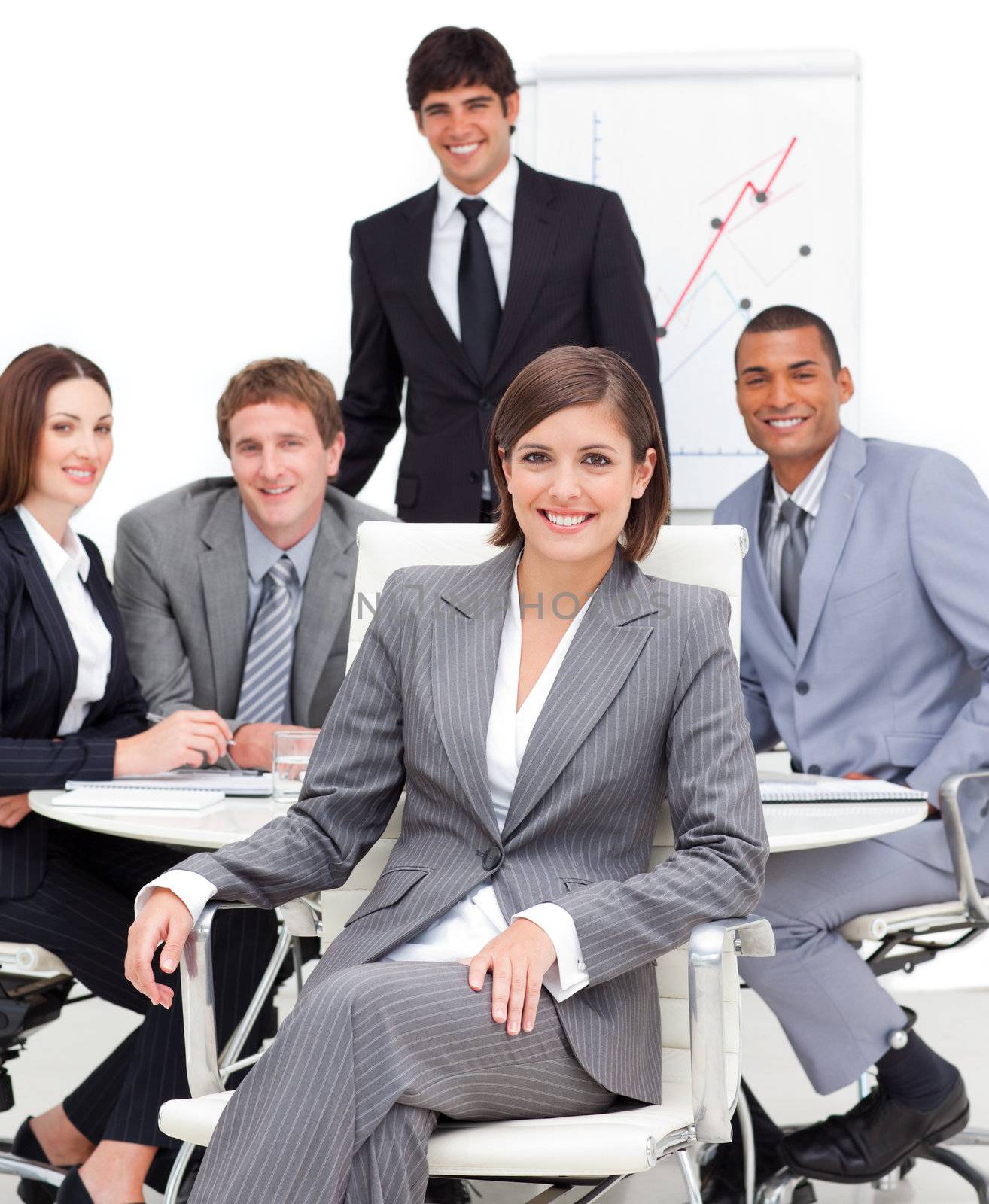 Assertive female executive sitting in front of her team in a meeting