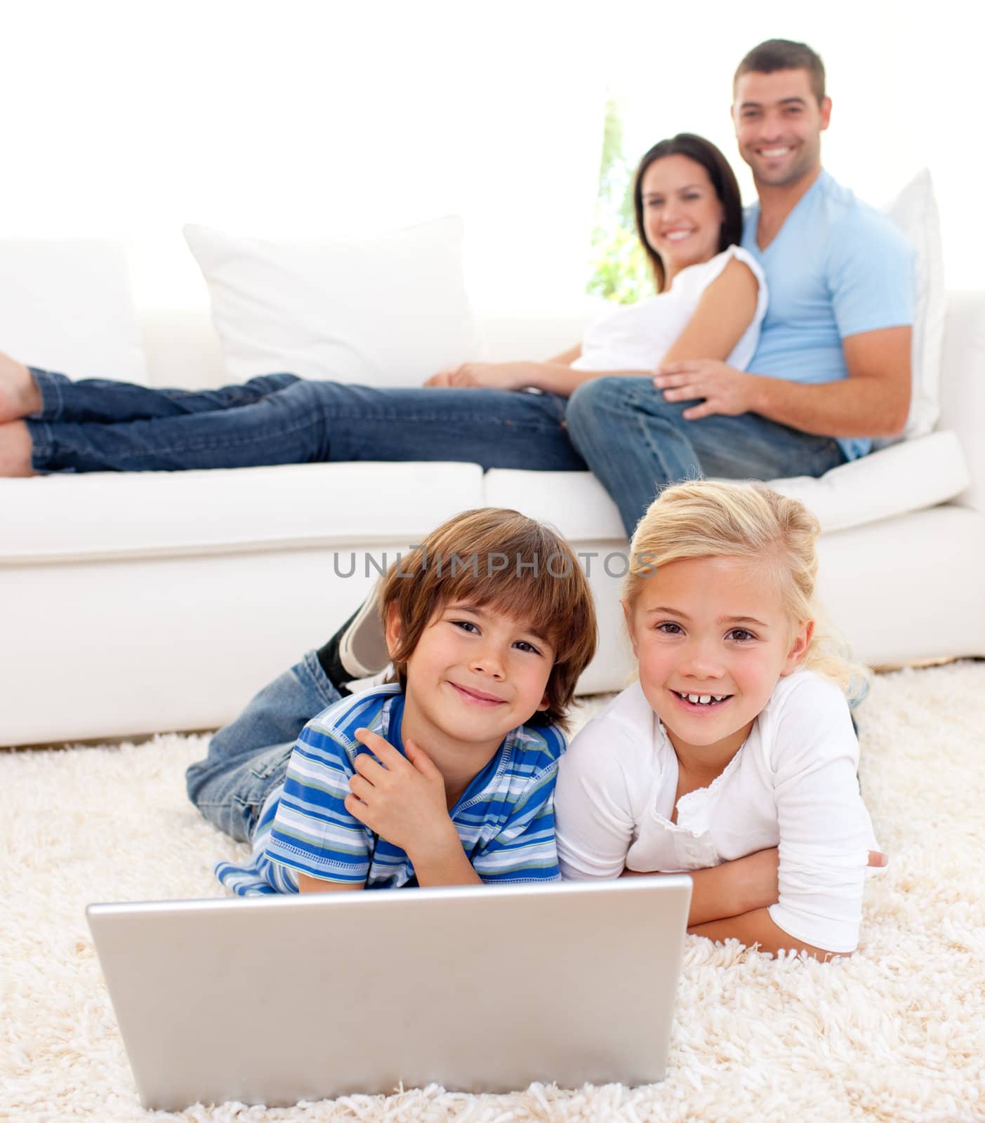 Loving family using a laptop in the living room by Wavebreakmedia