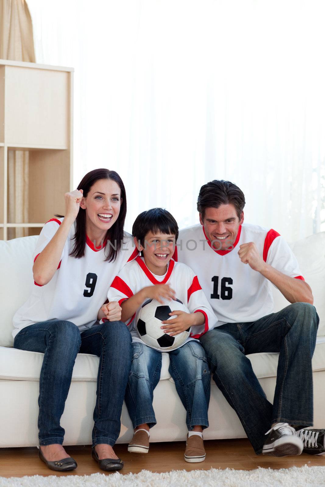 Lively family watching football match on television