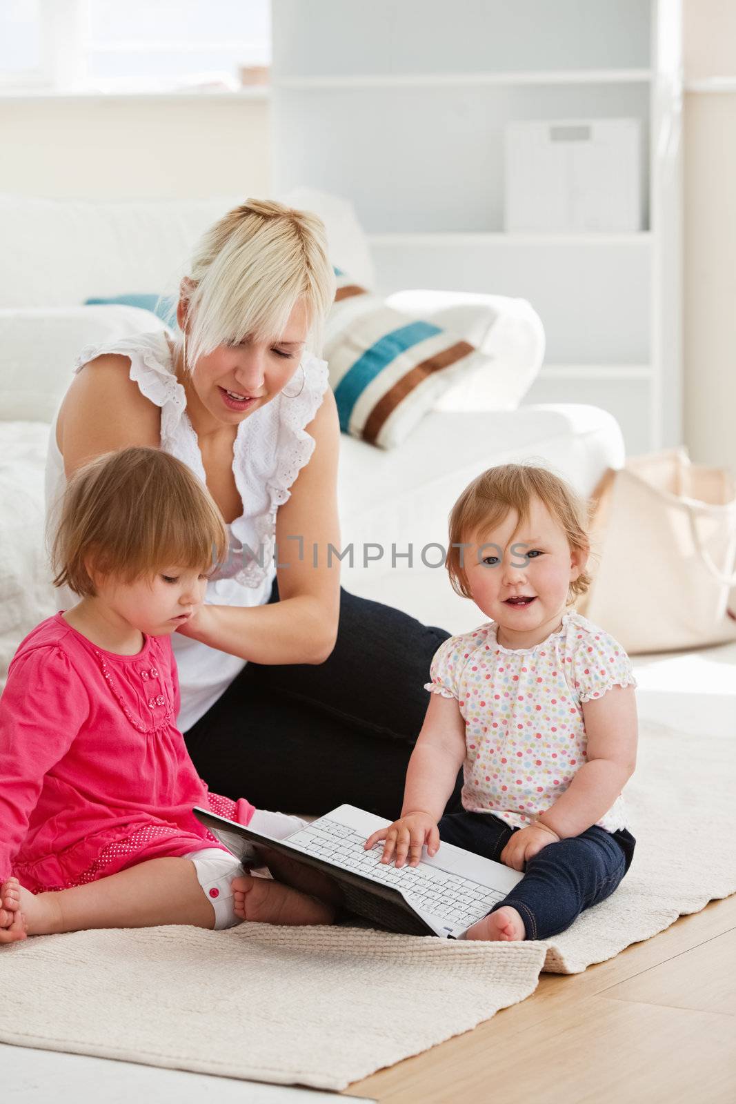 Good-looking working with her children at laptop in living room