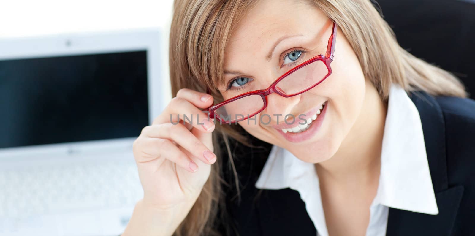 Charming businesswoman smiling at the camera sitting in her office