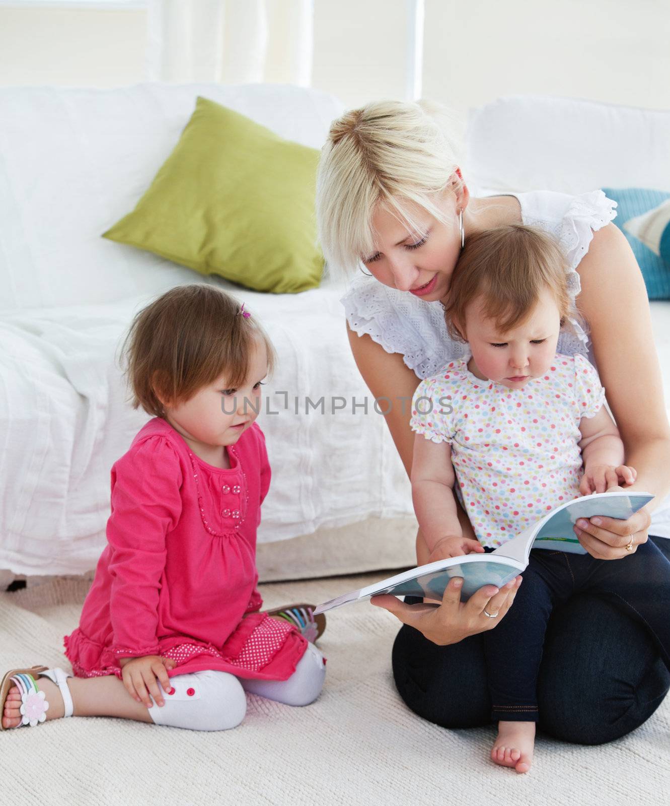 Small family reading a book in the living-room at home 