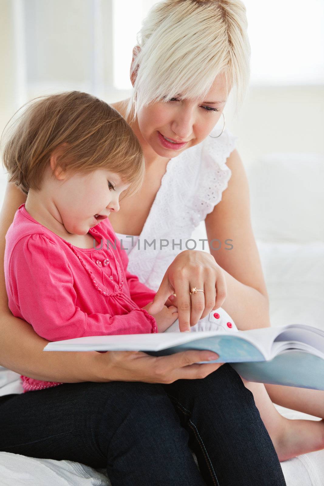 Young family reading a book by Wavebreakmedia