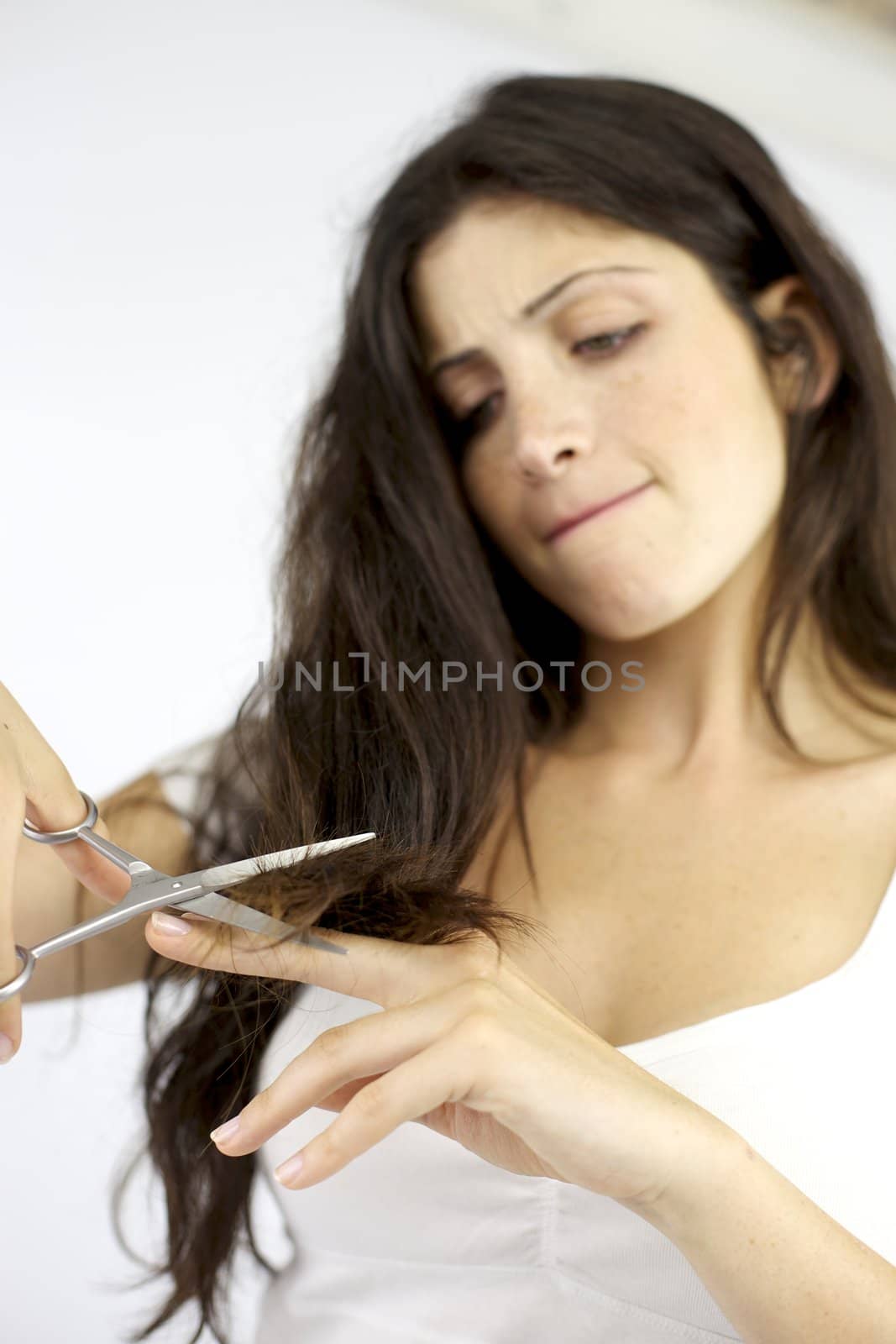 beautiful female model trying to cut split ends hair
