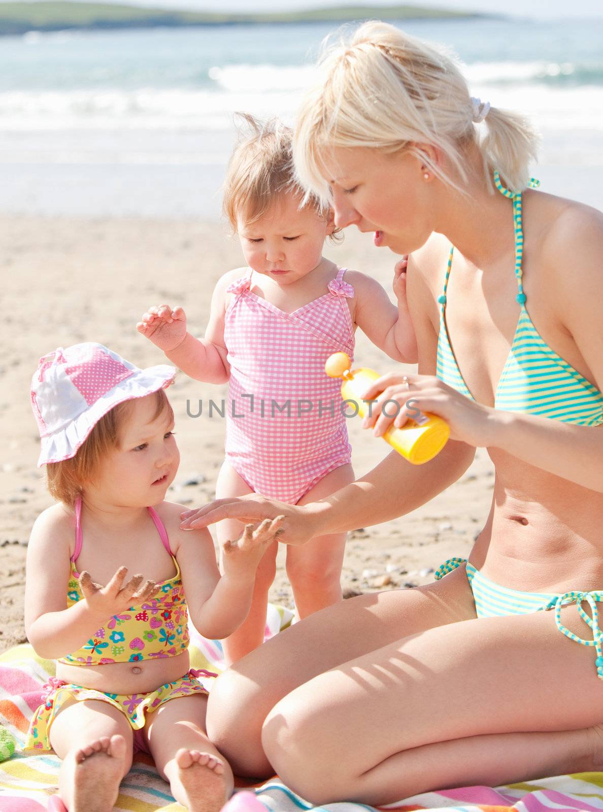 Happy young family at the beach by Wavebreakmedia
