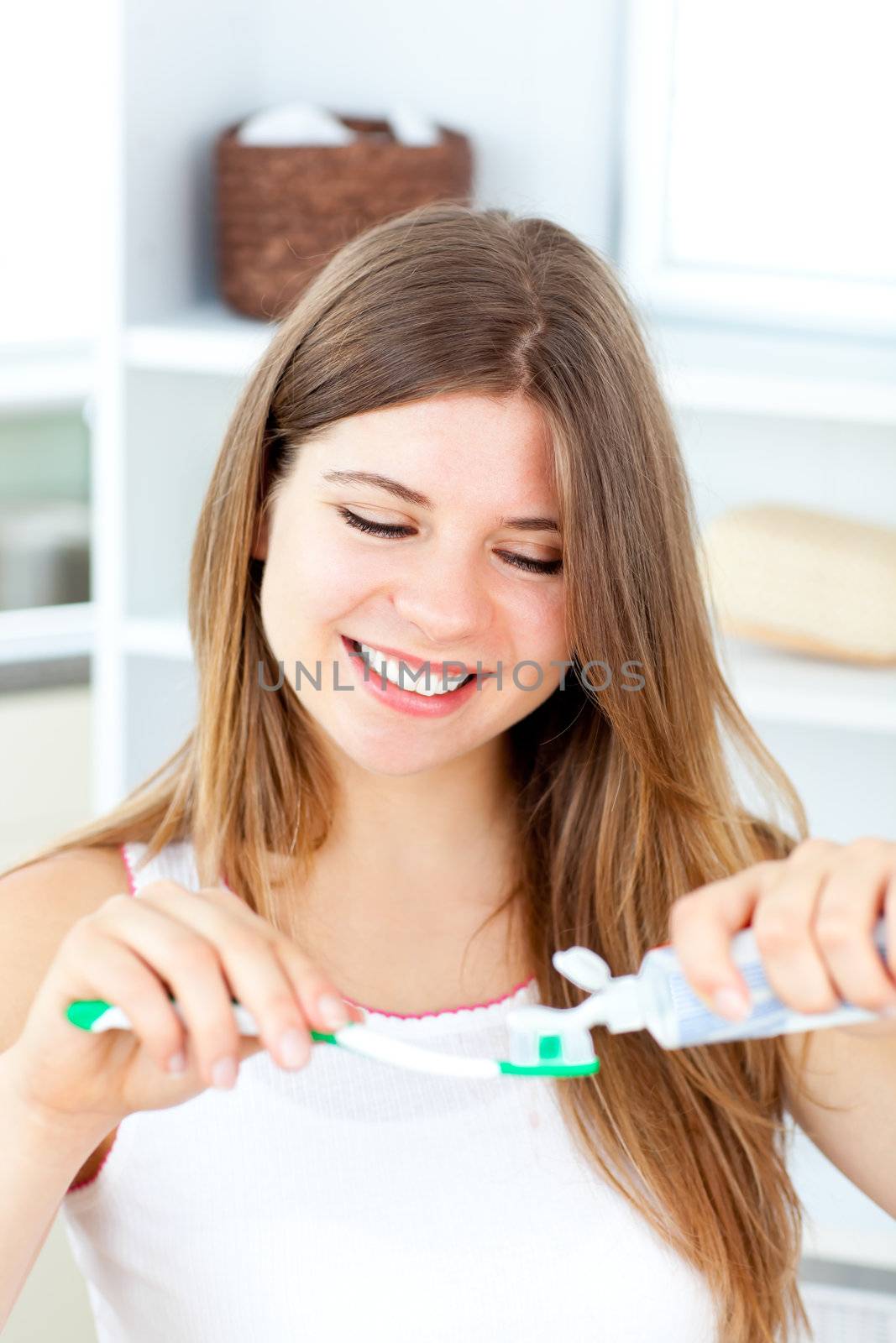 Merry woman using toothpaste in the bathroom by Wavebreakmedia