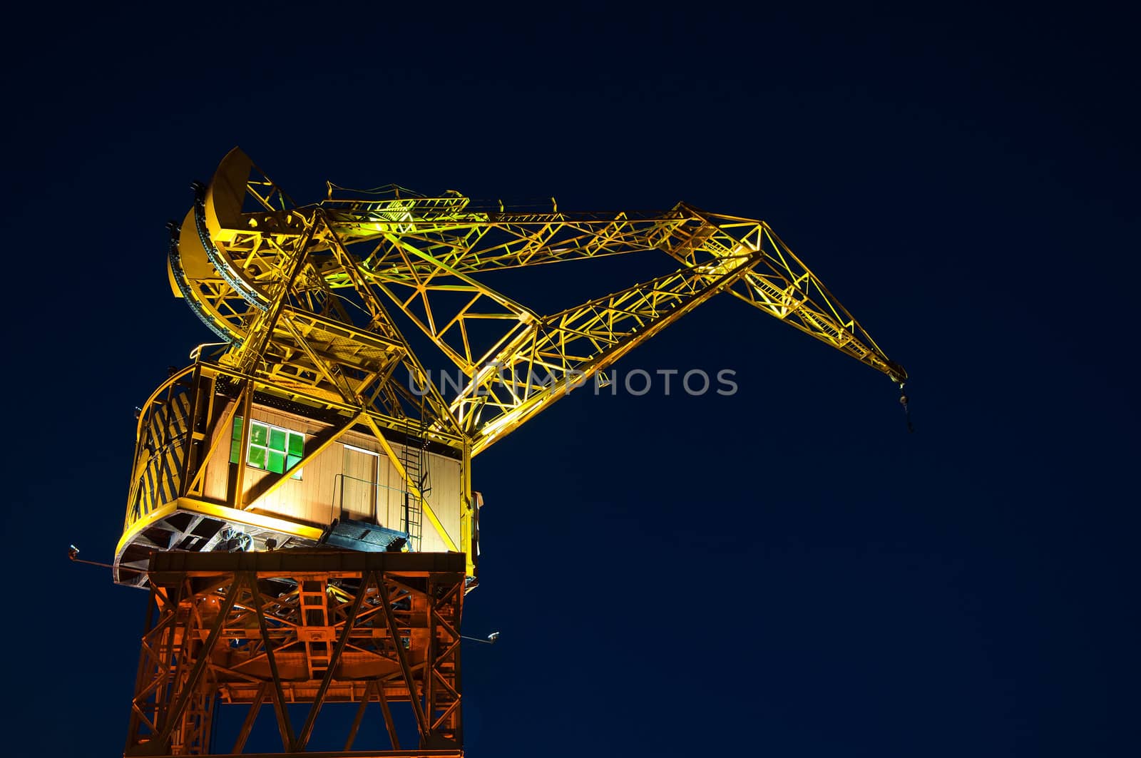 A yellow and orange crane seen at night.