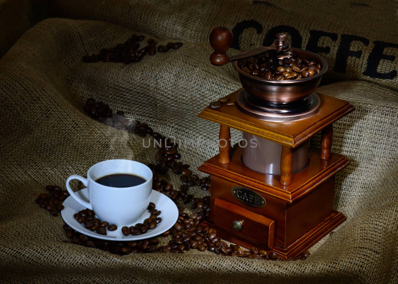 Coffee Mill with beans, cup and burlap. still life