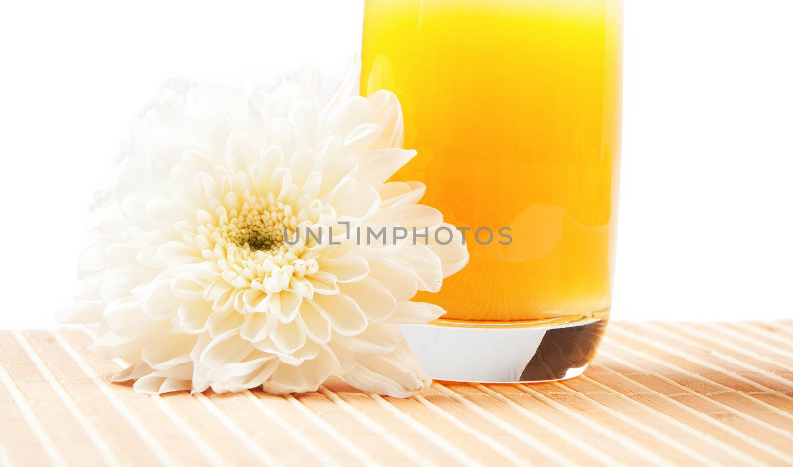 glass of orange juice and aster flower