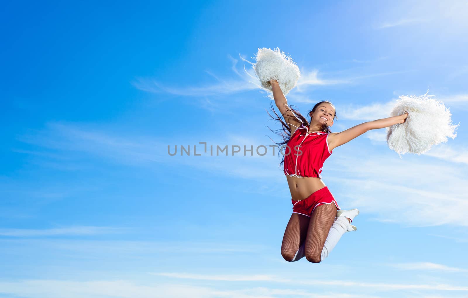 Young cheerleader in red costume jumping by adam121