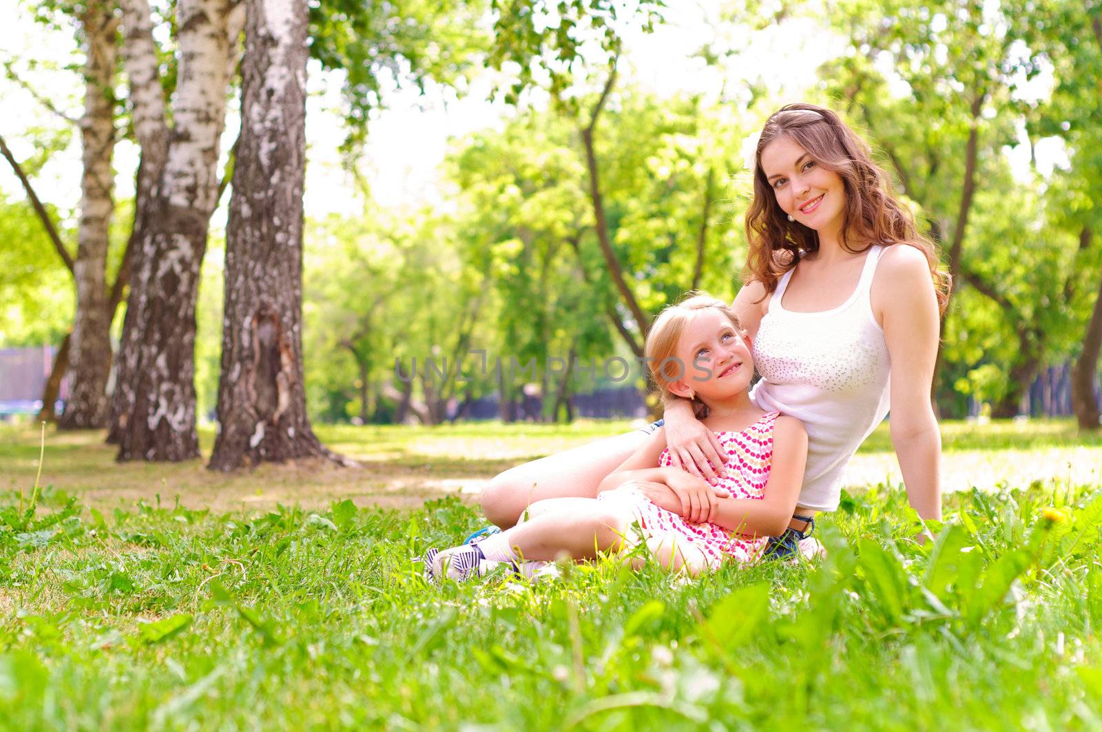 mother and daughter sitting together on the grass, and spend time with family