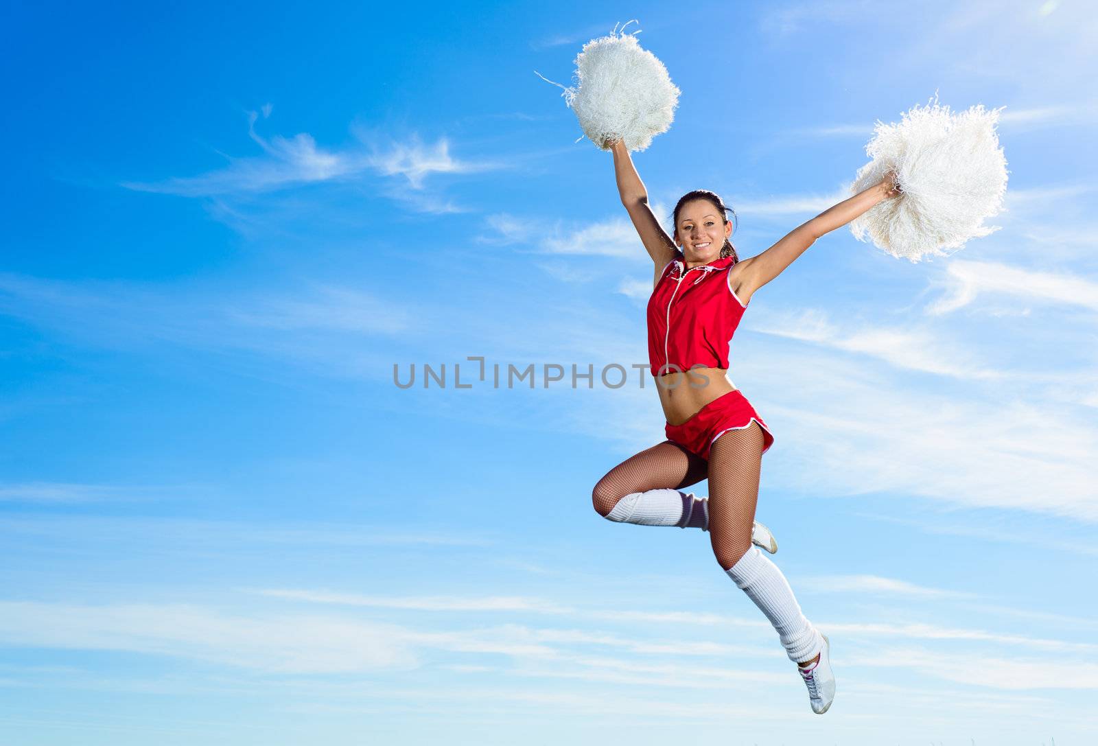 Young cheerleader in red costume jumping by adam121