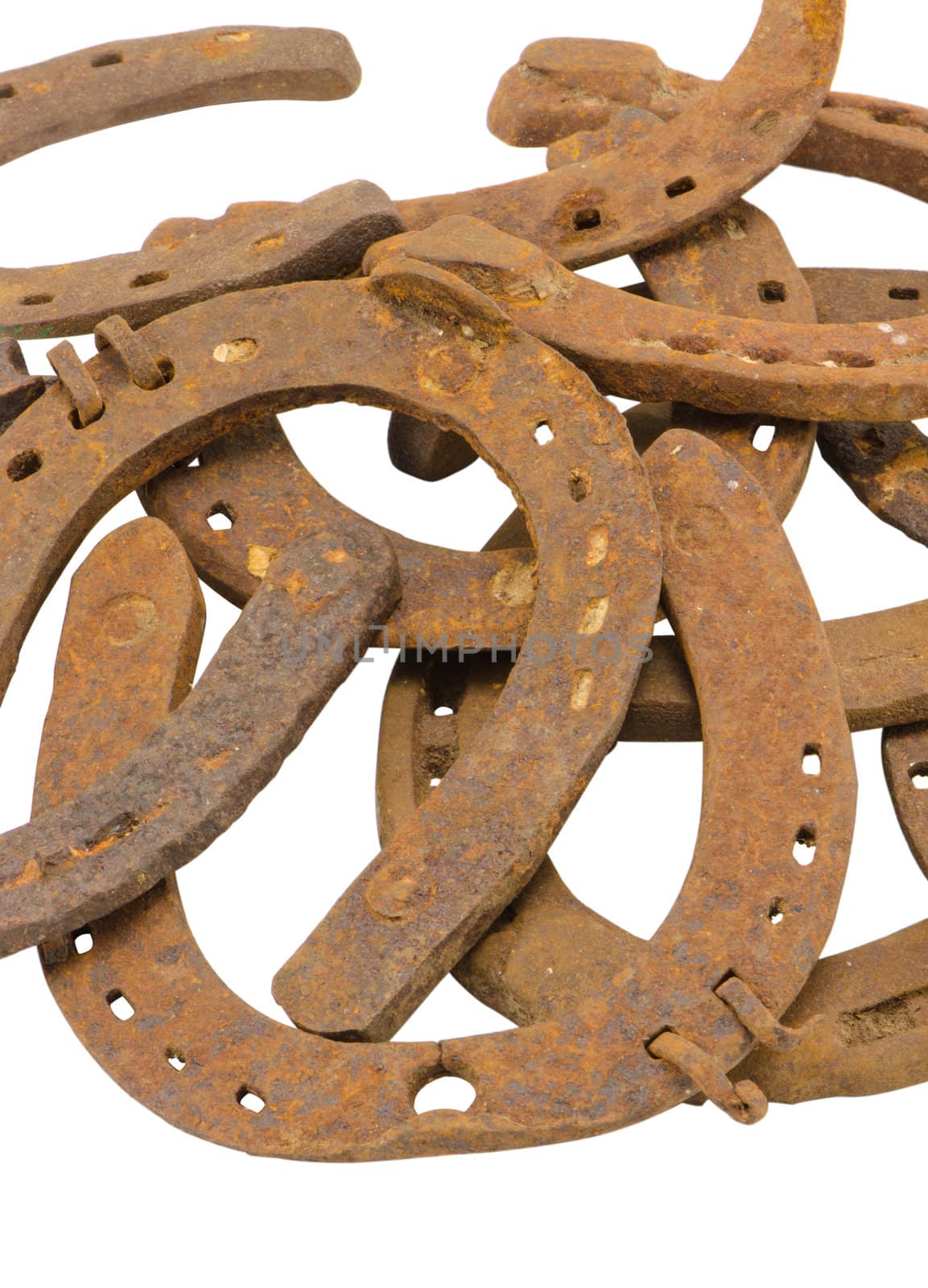 stack of old retro horse shoes isolated on white by sauletas