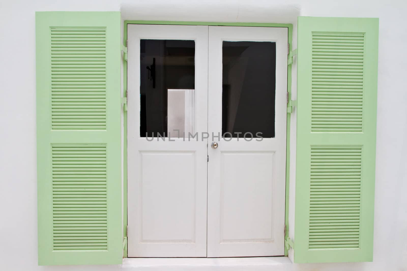 Green wooden window on the white house