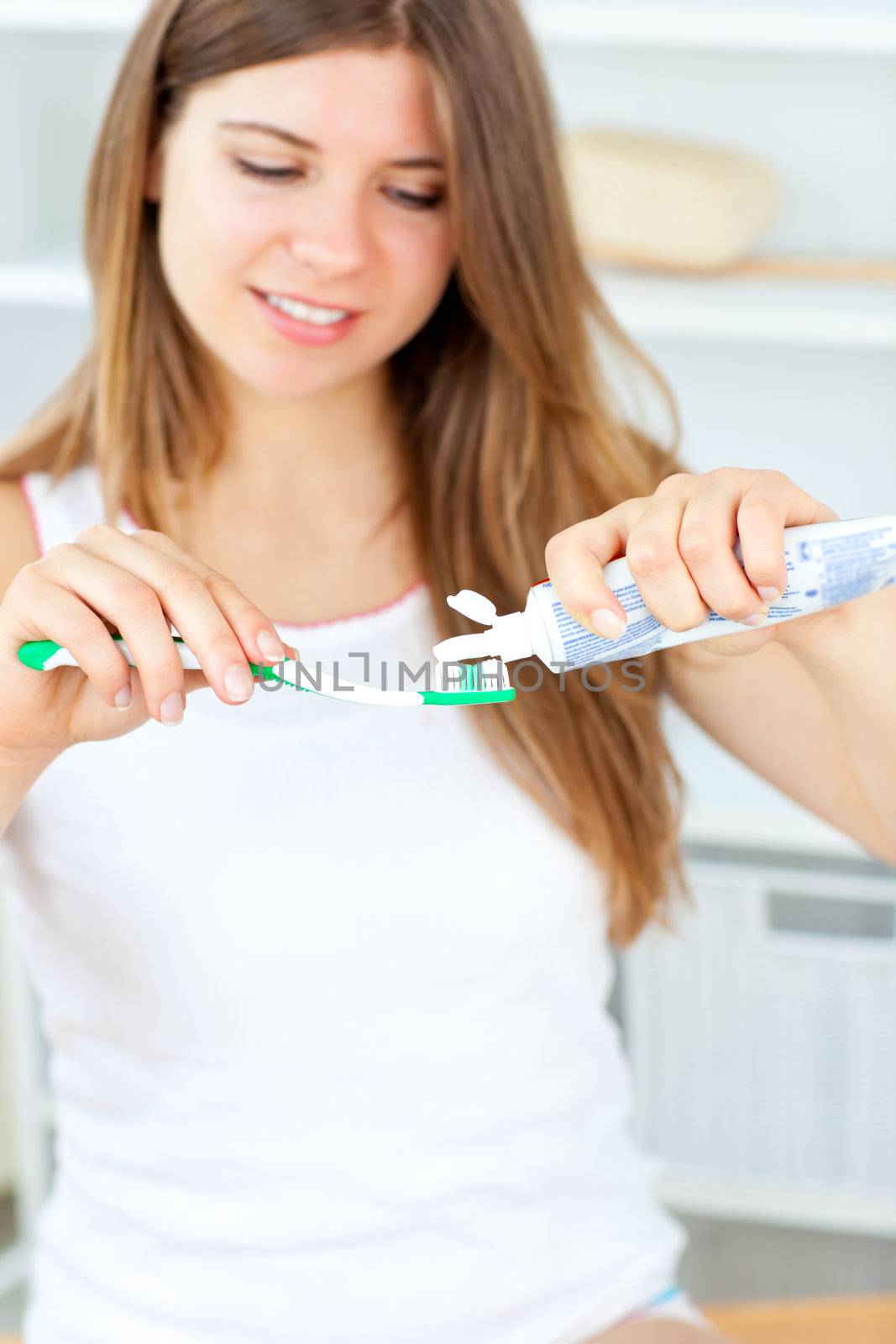 Beautiful woman using a toothbrush and toothpaste in the bathroom at home