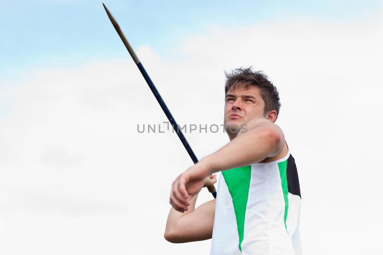Determined sportsman throwing the javelin outdoors