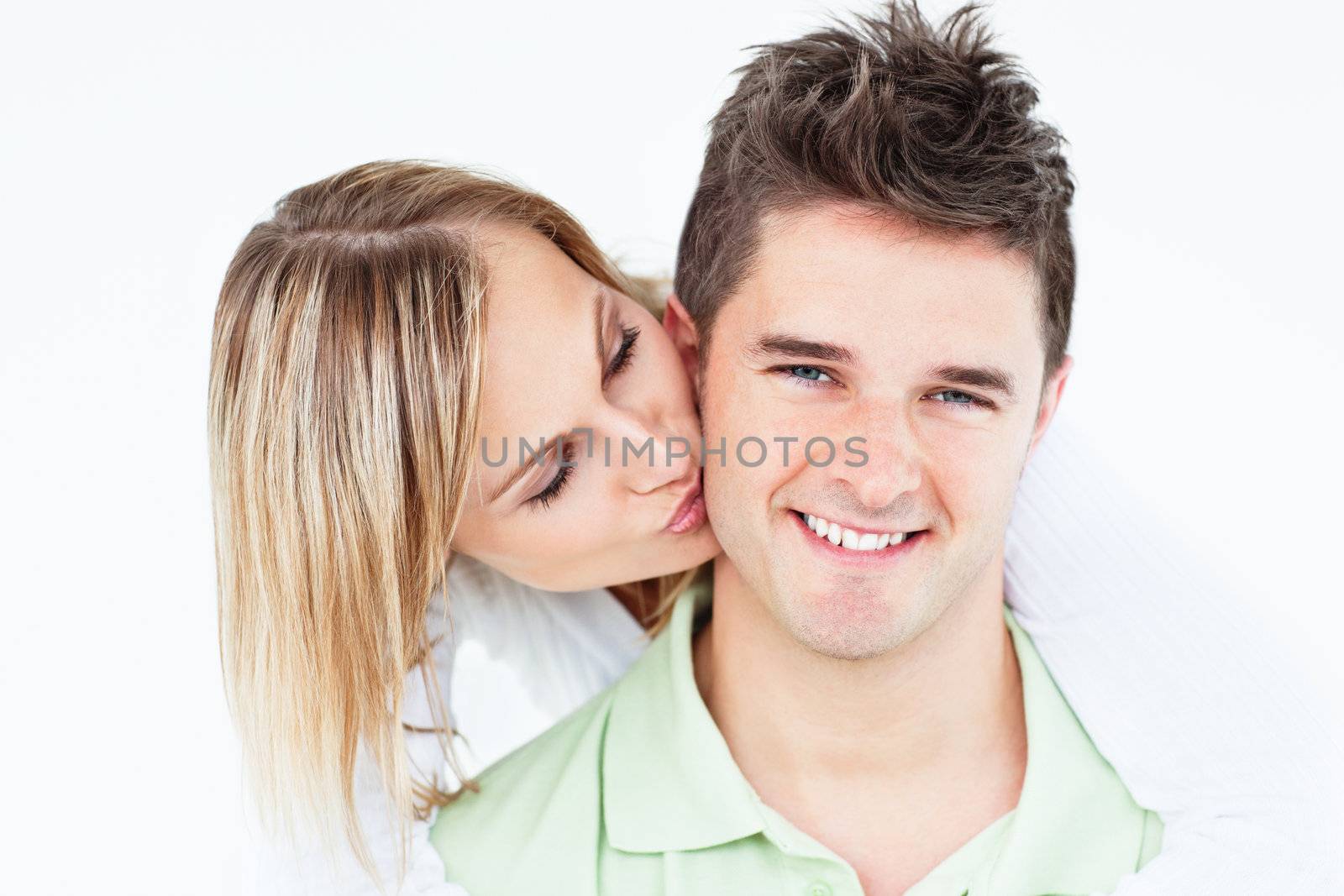 Happy smiling couple in love woman kissing her boyfriend over white background