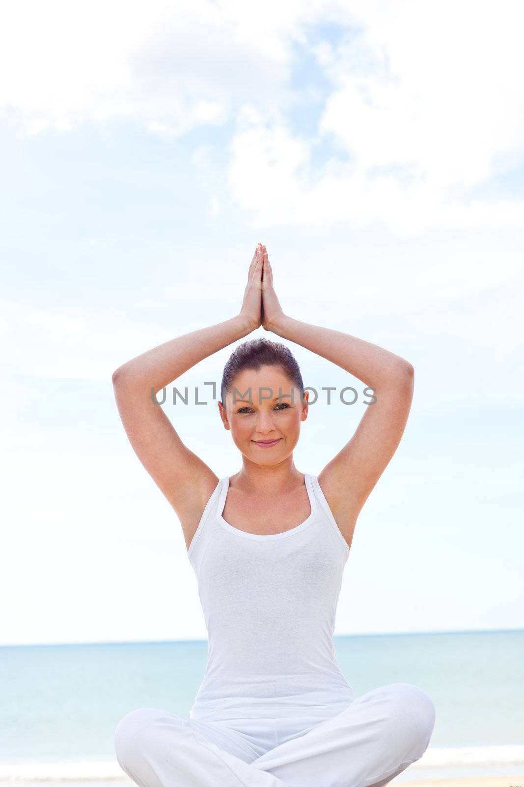 Young concentrated woman doing yoga on beach  by Wavebreakmedia