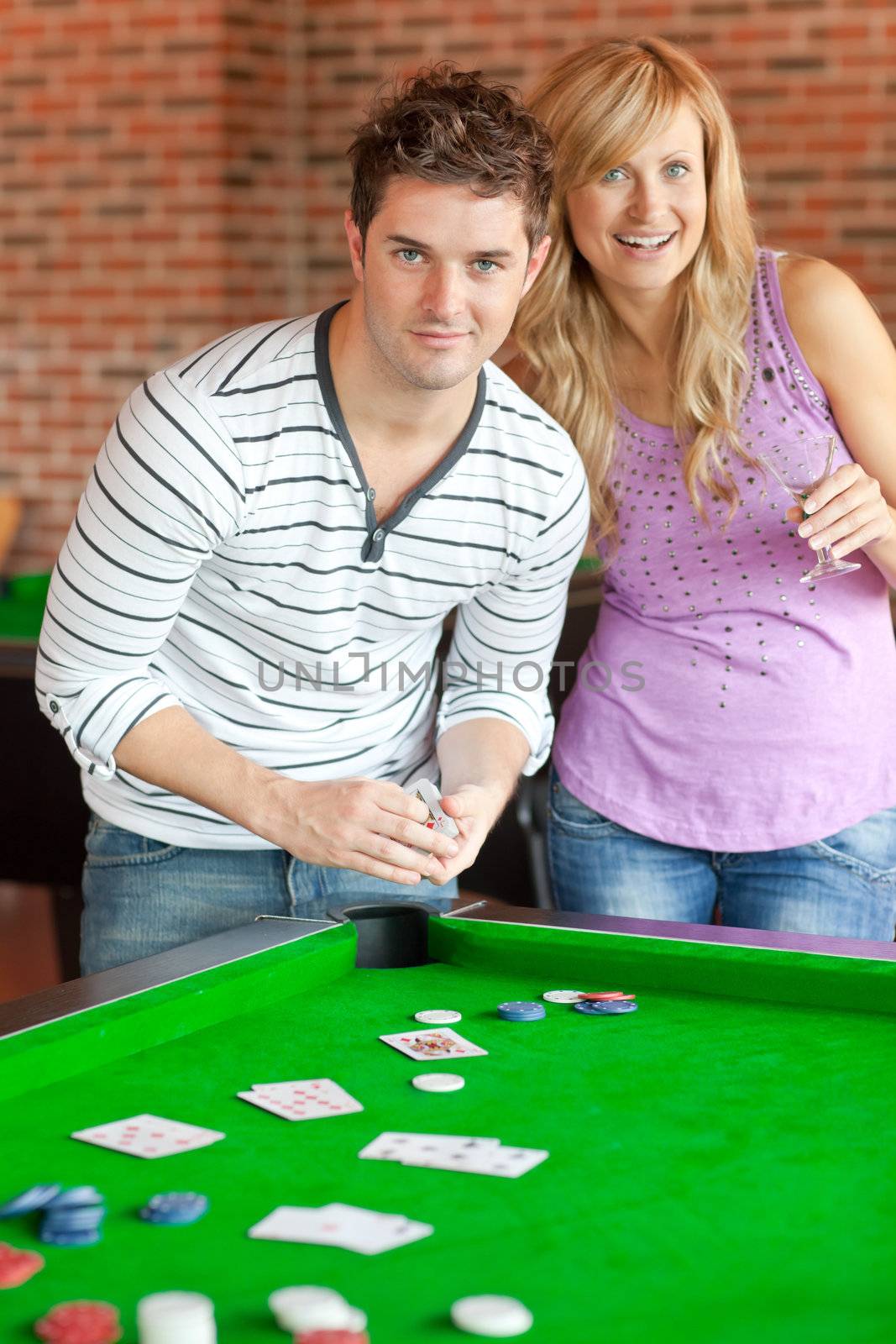 Caucasian couple playing cards on a billiard by Wavebreakmedia