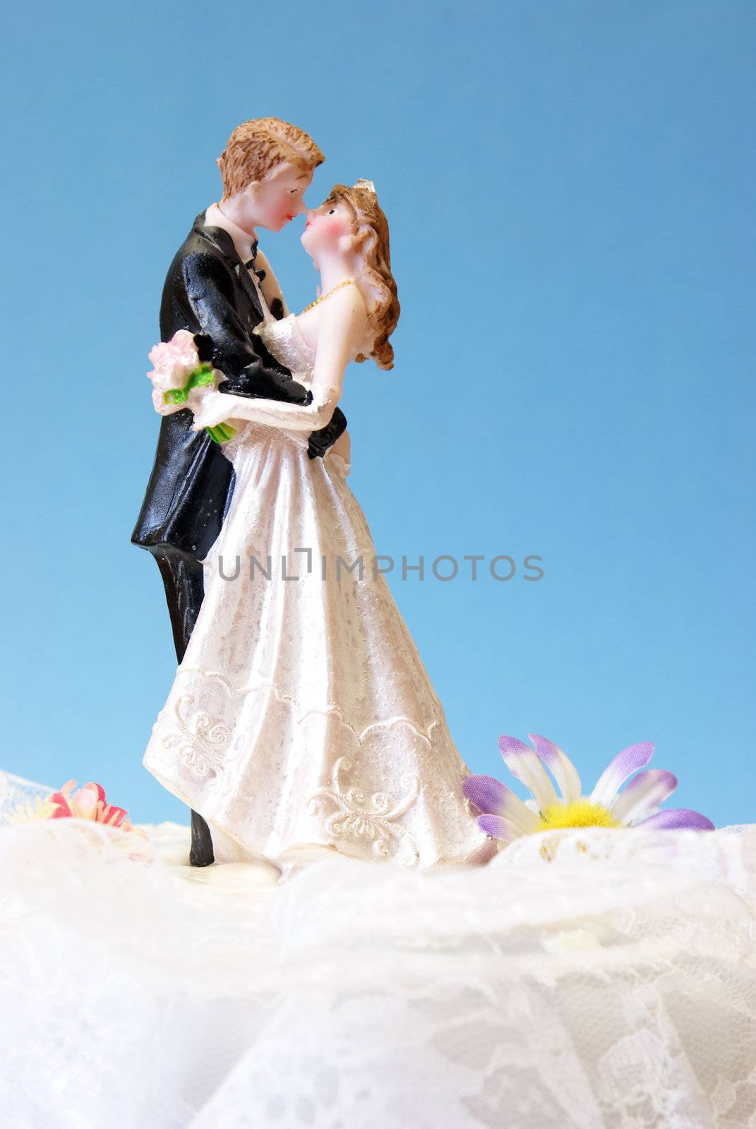 A wedding cake topper on top of the newlyweds dessert.