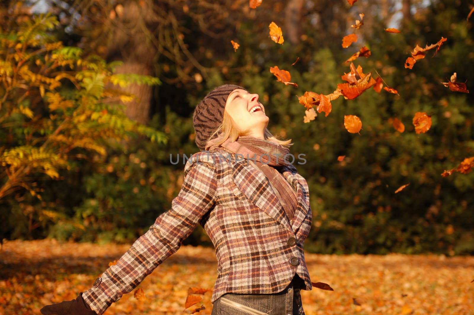 Young woman enjoying sunny day in autumn in the park
