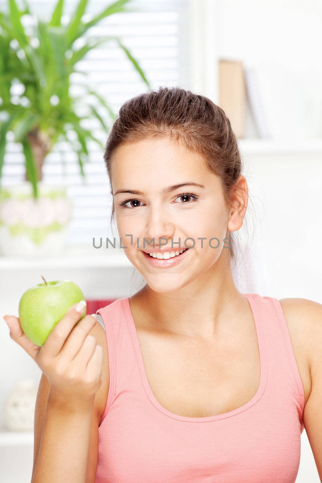 happy young woman at home with green apple