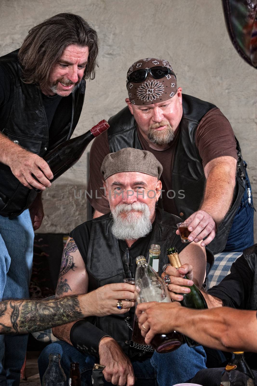 Smiling gang members toasting with bottle of liquor