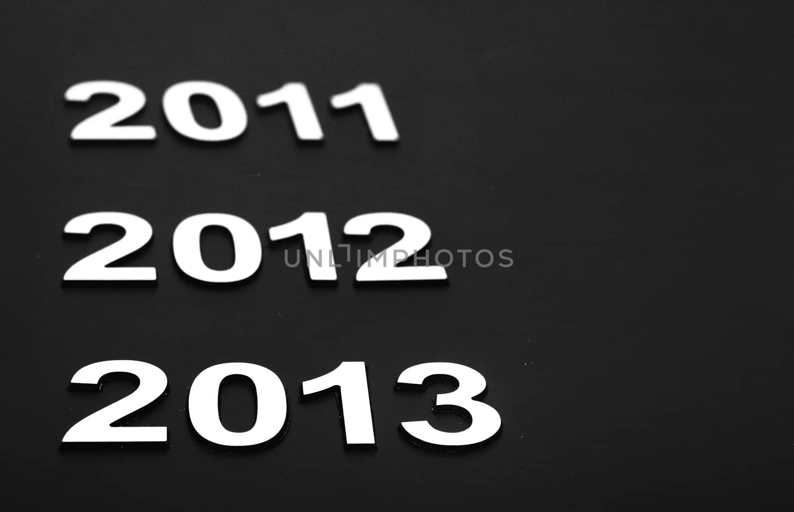 Upcoming years 2011, 2012 and 2013 as chrome digits over black background 