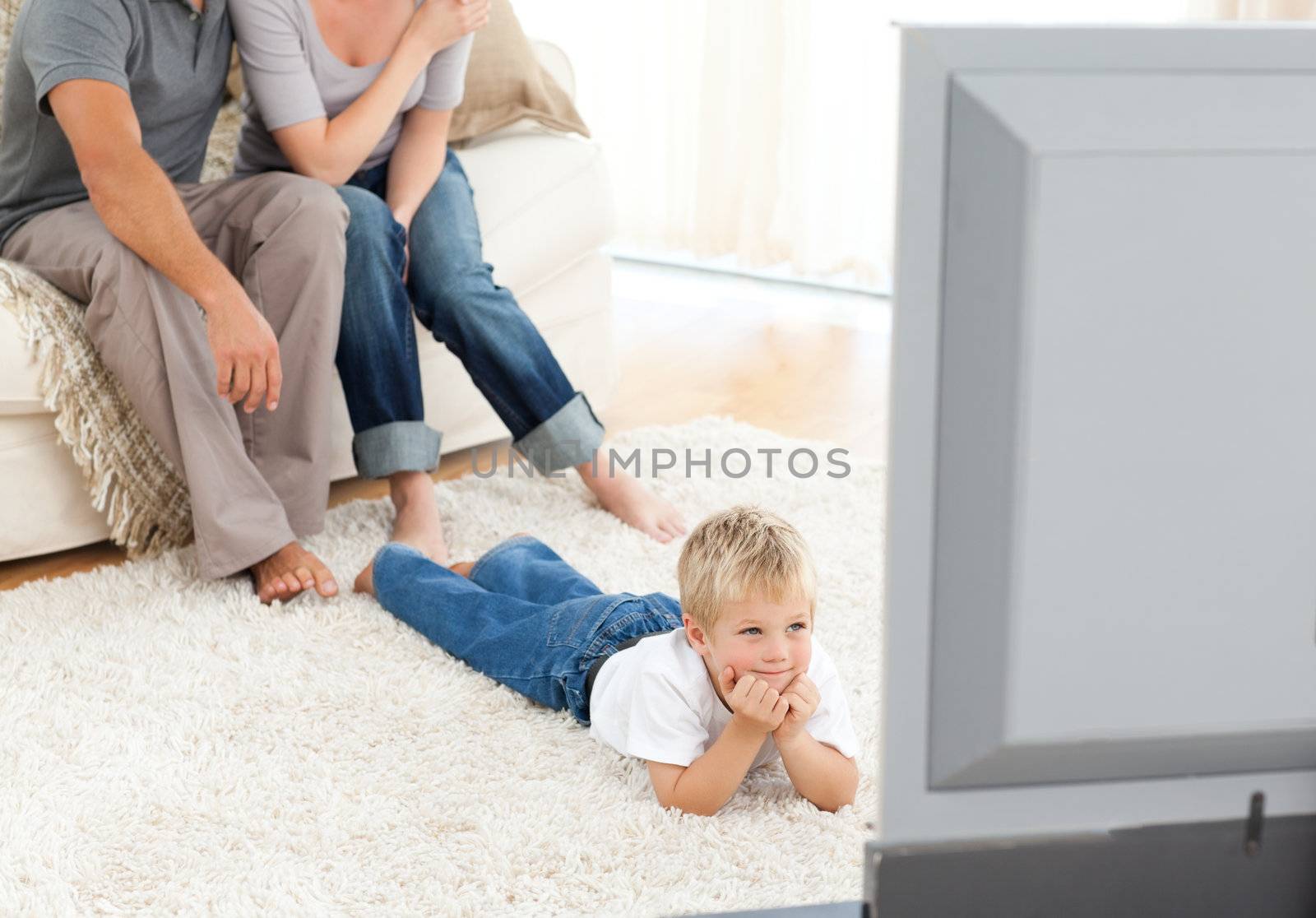 Attentive little boy watching television lying on the floor by Wavebreakmedia