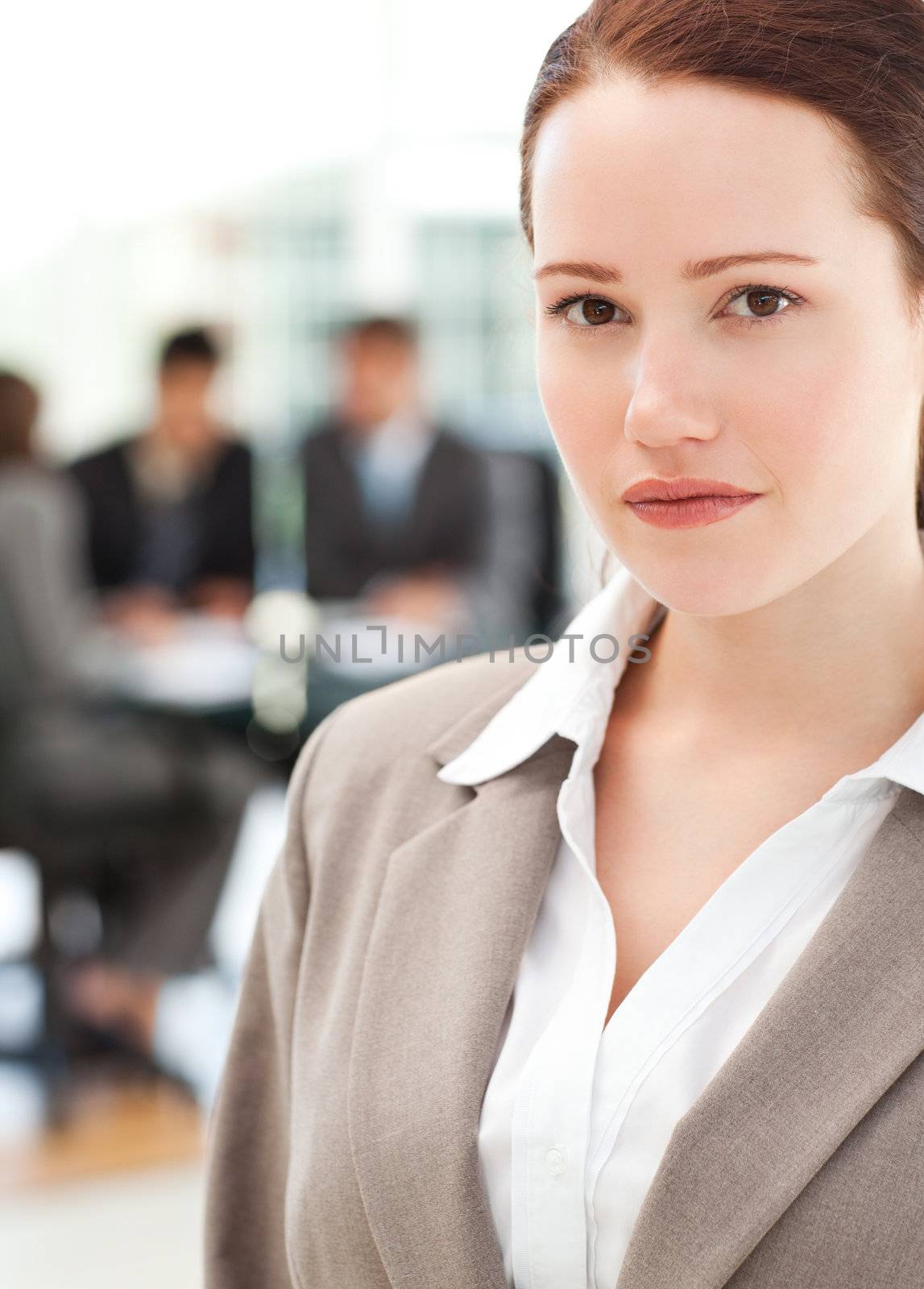 Attractive businesswoman during a meeting with her team standing in the foreground